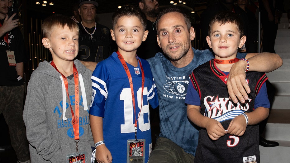Michael Rubin posing for a photo with kids at Fanatics Fest