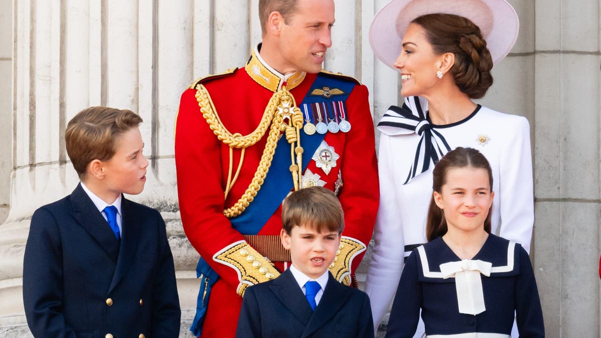 Prince William and his family standing together on the balcony of Buckingham Palace.