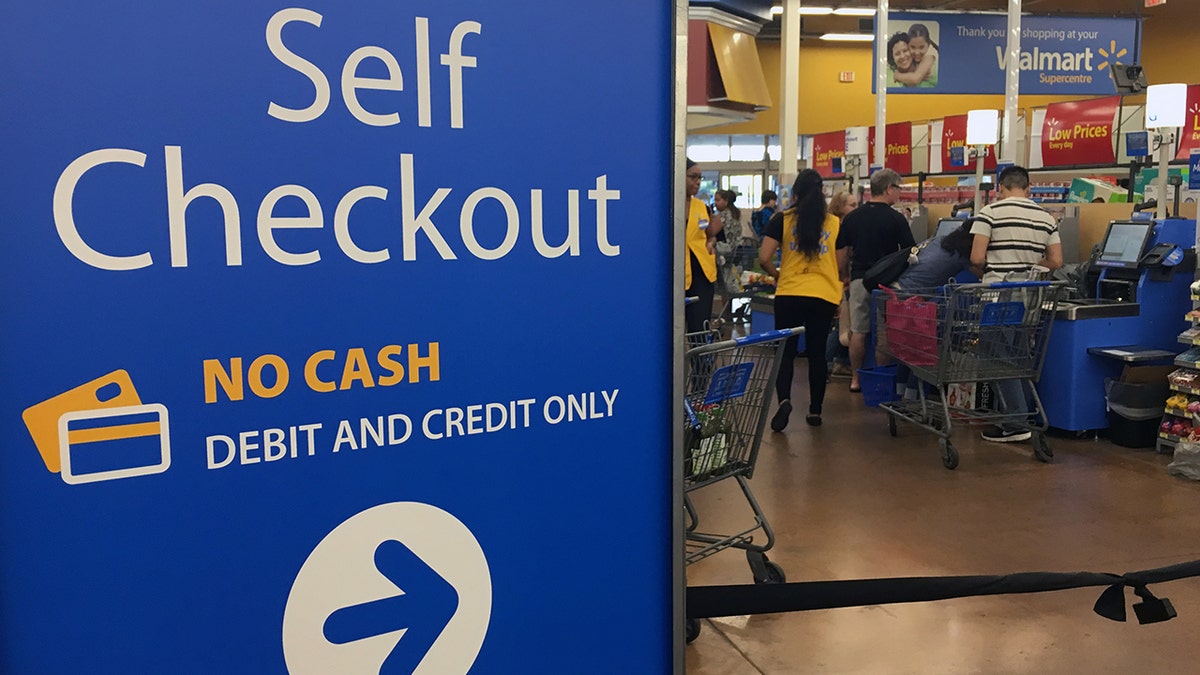 A sign at Walmart reads: "Self Checkout No Cash Debit And Credit Only."